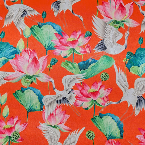 Polyester silk fabric with red-headed cranes and pink lotus flowers with large green leaves on bright orange silk used to created Vietnamese Lanterns in Hoi An.
