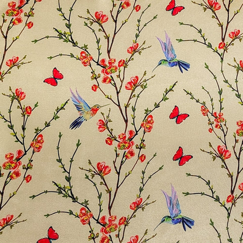 Polyester silk fabric featuring a print of hummingbirds in flight with red and pink flowers against cream.