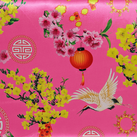 Polyester silk fabric used to created Hoi An Lanterns featuring a design of cranes, traditional lanterns, firecrackers, and pink and yellow blooms on a vibrant pink background.