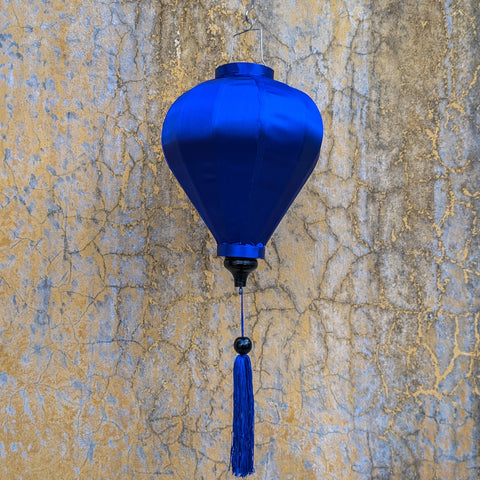 Blue balloon shaped lantern hanging in front of an old wall in Old Town, highlighting the blue in the wall.