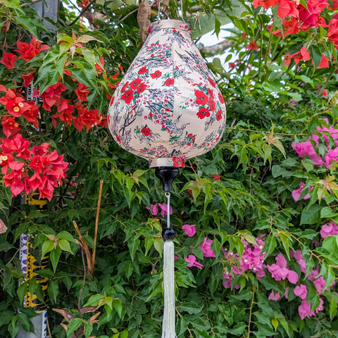 Garlic shape Vietnamese silk lantern handmade in Hoi An , Vietnam set against Bougainville with red flowers on luxury creamy silk fabric.
