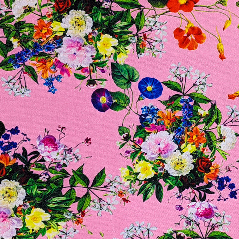 Pink polyester silk fabric with bouquets of wild flowers in every shade of the rainbow.
