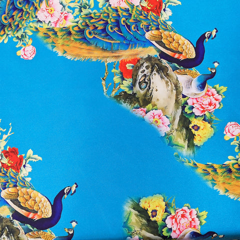 Silk fabric used for creating our handmade Vietnamese silk lanterns with print featuring peacocks and blossoms in blue, pink and red on a deep blue background.