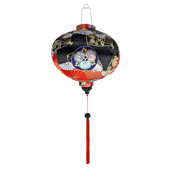 Round Vietnamese silk lantern with red tassel and an abstract print in red, black, blue and gold outline.