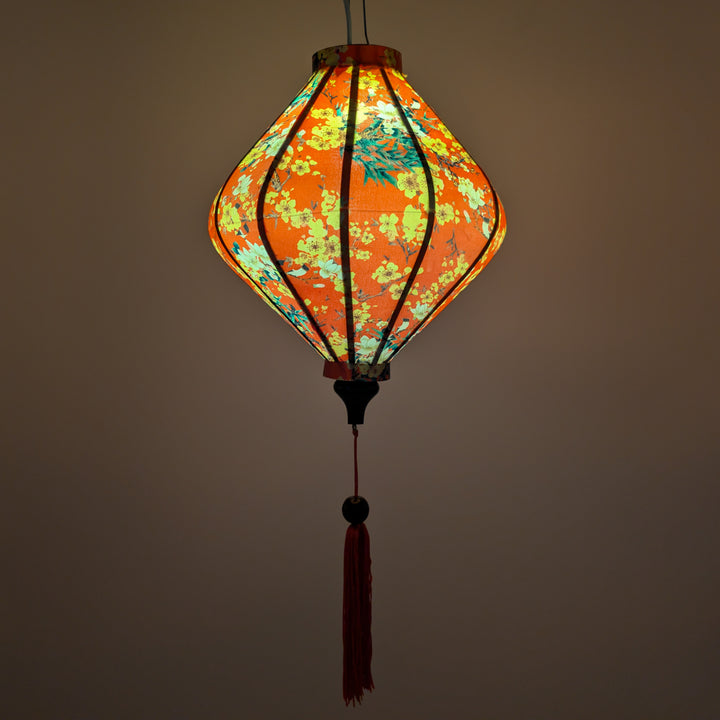 Glowing lozenge shape lantern with yellow floral patterns on red.