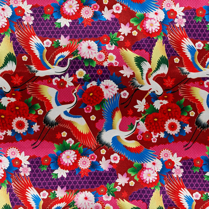 Polyester silk fabric with cranes, their wings gracefully cascading in shades of white, gold, red, and blue. Their backdrop is lush with red and pink flowers, foliage, and dark, majestic purples. 