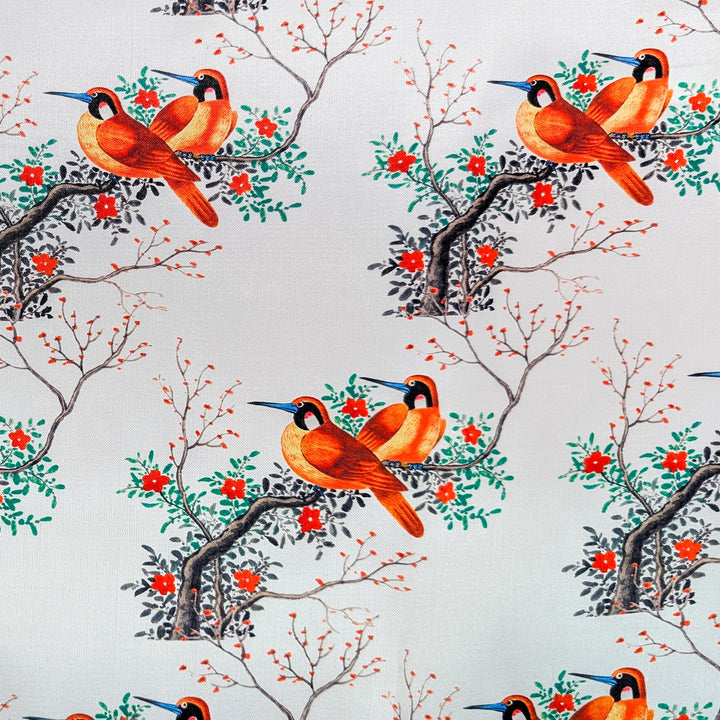 Polyester silk fabric with a pattern of orange birds on branches with red flowers on a white background