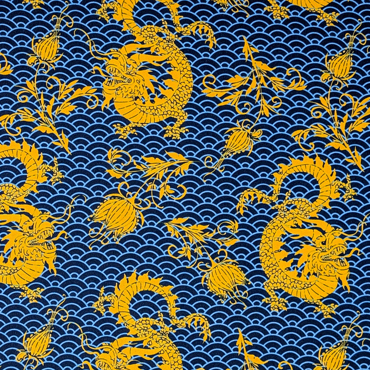 Polyester silk fabric used to create Vietnamese silk lantern featuring a pattern of golden yellow dragons and flowers on a dark blue background with blue sea swirls.