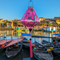 Teardrop shaped Vietnamese lantern  with pink tassel hanging in front of a beautiful scene in the Ancient City of Hoi An.