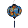 Glowing round lantern with wild flowers against blue.