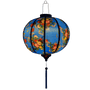 Glowing round lantern with wild flowers against blue.