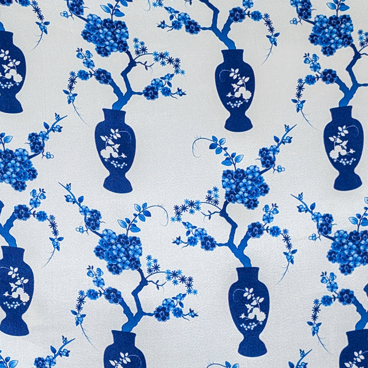 Pattern of blue vases and floral branches on a white background