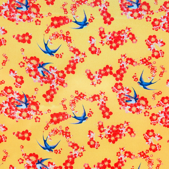Polyester silk fabric with a pattern of blue birds and red flowers on a yellow background