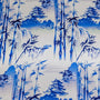 Polyester silk fabric featuring a blue print of temples and pagodas high above hilltops with large bamboo trees floating against white background. 