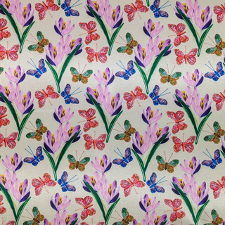A close up of polyester silk fabric with a stunning print of blue, red and green butterflies fluttering around pink and purple flowers.