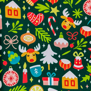 Close up of polyester silk fabric with a Christmas theme featuring reindeer, candy sticks, bells, ice capped trees, candles, gift wrapped gifts and mistletoe on a deep green background.