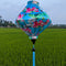 Lozenge shaped lantern against rice field in Hoi An featuring cranes in flight surrounded by pink lotus flowers on blue.
