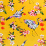 Polyester silk fabric with a print of red headed cranes with flowers on their wings holding lanterns in their beaks on yellow.