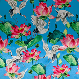 Polyester silk fabric used to created Hoi An Lanterns featuring black-necked cranes in flight and lotus flowers in bloom with large green leaves on a vibrant blue background.