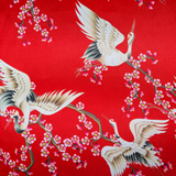 Red polyester silk with red-headed cranes flying and swooping around small pink and white cherry blossoms.