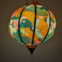 Lantern with floral and crane design creating an orange glow