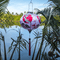 Round lantern with red tassel outdoors in front of the Thu Bon River in Hoi An.