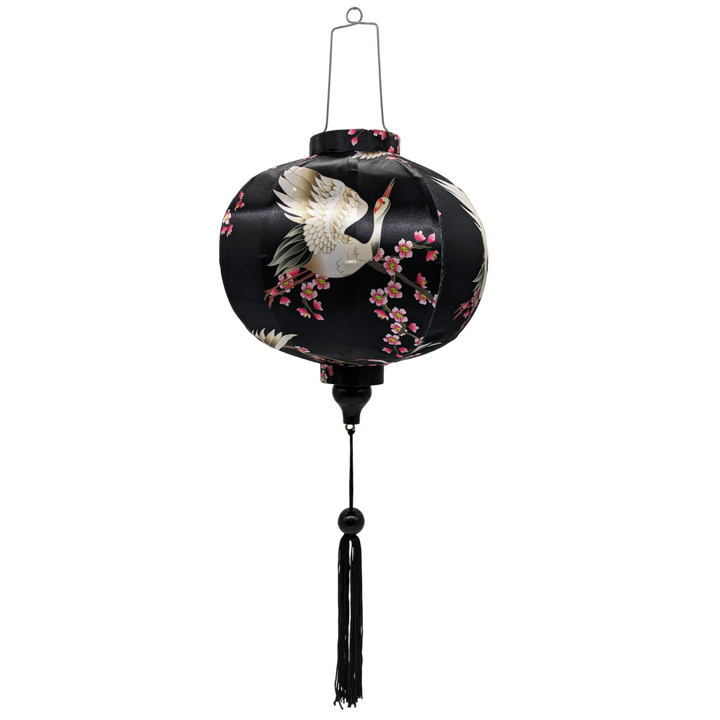 Round shaped Vietnamese Hoi An lantern featuring red-headed white cranes amongst pink cherry blossoms against a black background.