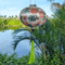 Round Vietnamese silk lantern with green tassel and print of green and blue dragons in the wild.