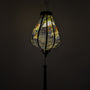 Garlic shape hanging lantern with intricate designs against a dark background