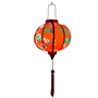 Glowing Round Vietnamese lantern with red tassel with black, yellow and green lanterns and multi colour fans surrounded by white cherry blossoms on a bold red background.