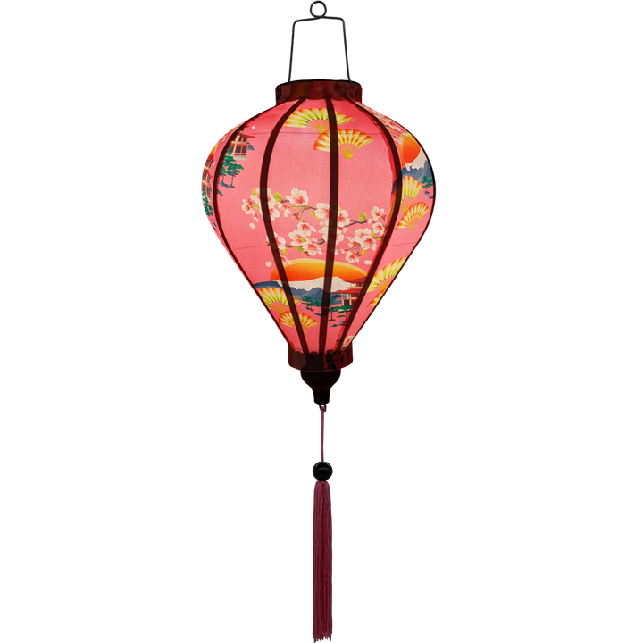 Glowing Balloon shaped Vietnamese Hoi An Lantern with pink tassel  and a design of yellow fans, a house overlooking trees beneath snow capped mountains and surrounded by blooms of pink on a brilliant pink background. 