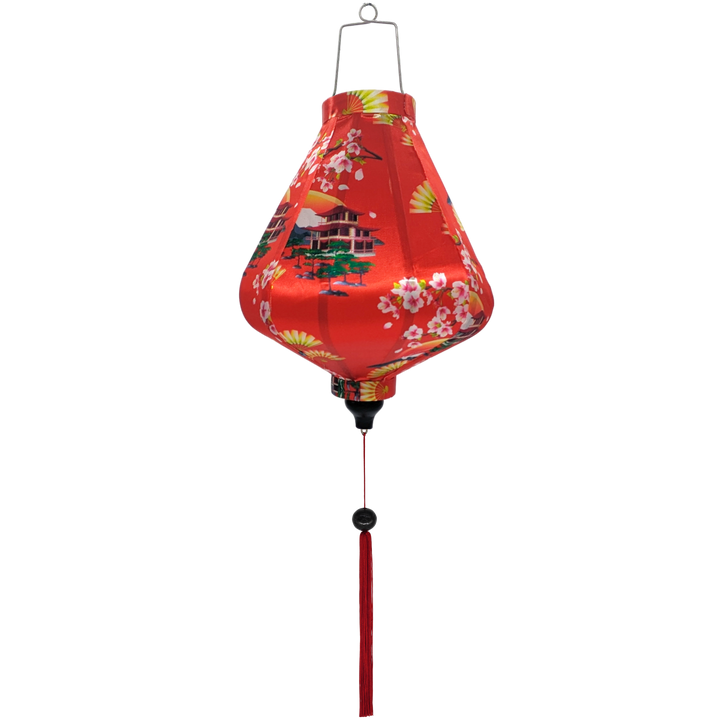 Teardrop shaped Vietnamese lantern with red tassel and design of yellow fans, a house overlooking trees beneath snow capped mountains and surrounded by blooms of pink on a brilliant red background. 