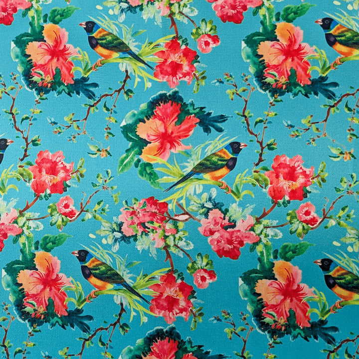 Polyester silk fabric with finches perched in a hibiscus tree filled with pink and peach colour flowers in bloom on blue background used to create Hoi An Vietnamese silk lanterns.