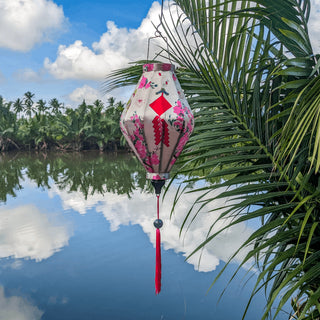 Tube shaped Vietnamese lantern hanging in front of the Thu Bon River in Hoi An.