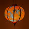 Glowing Round Vietnamese lantern with orange hue.