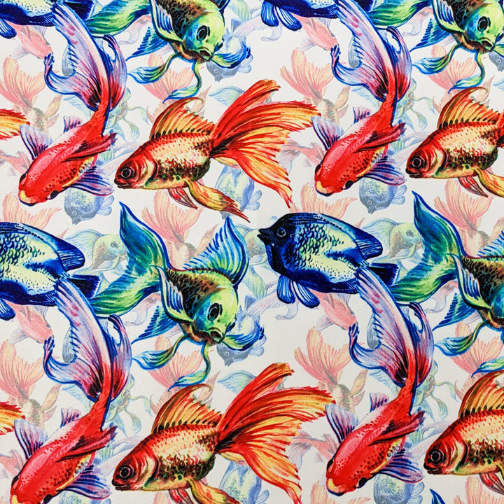 Polyester silk fabric used for Hoi An Silk Lanterns features orange, green and blue fish swimming on a white background.