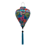 Balloon shaped lantern with blue tassel made with steel, bamboo and fabric with a vibrant and modern floral design on a blue background. 