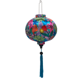 Round shaped lantern with blue tassel made with steel, bamboo and fabric with a vibrant and modern floral design on a blue background. 