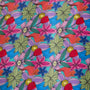 Up close of polyester silk fabric with a print of vibrant and modern floral design with bold, shapes on a blue background. 