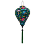 Balloon shaped lantern with green tassel featuring a print of lush, tropical-inspired design with birds and flowers on a deep green silk fabric. 