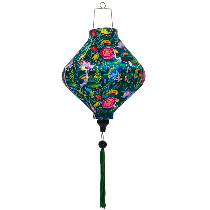 Lozenge shaped lantern with green tassel featuring a print of lush, tropical-inspired design with birds and flowers on a deep green silk fabric.