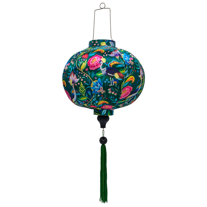 Round shaped lantern with green tassel featuring a print of lush, tropical-inspired design with birds and flowers on a deep green silk fabric.
