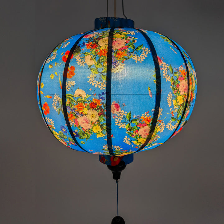 A glowing blue hue is created by these Vietnamese lanterns featuring wild flowers in a rainbow of colours against a blue background.