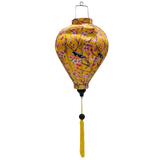 Balloon shaped Vietnamese Hoi An Lantern with yellow tassel and print of  yellow and bright blue and orange flycatcher birds sitting in a cherry tree set against a sunny yellow background. 