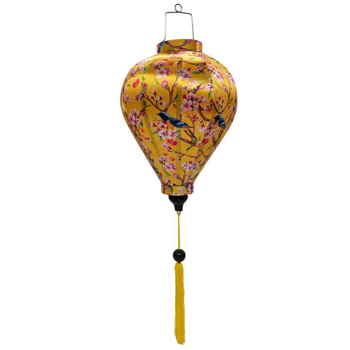 Balloon shaped Vietnamese Hoi An Lantern with yellow tassel and print of  yellow and bright blue and orange flycatcher birds sitting in a cherry tree set against a sunny yellow background. 