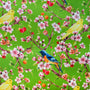 A vibrant fabric design featuring a lush green background with delicate cherry blossoms in full bloom. The branches are adorned with clusters of pink and white flowers, along with small red and orange cherries. Among the blossoms, bright yellow canaries and striking blue and orange flycatchers are perched.