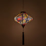 Glowing lantern with golden dragon and red clouds on a black background.