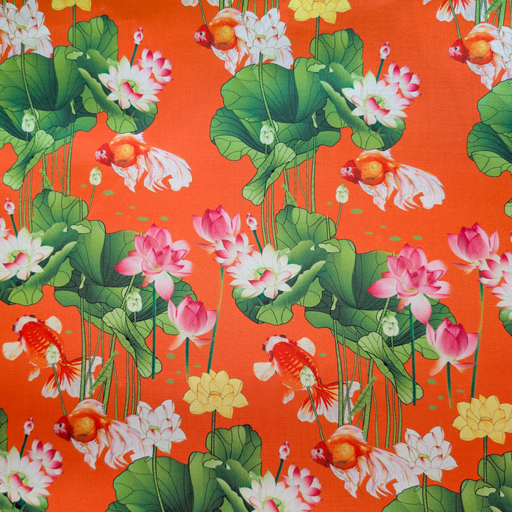 Fabric with a vibrant pattern of goldfish, lotus flowers, and green leaves on an orange background.