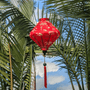 Lozenge shaped Vietnamese Hoi an Lantern on the Thu Bon River with reflections of clouds in the river with palm trees.