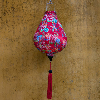 Phoenix birds, dragons and floral lantern with a red tassel against a textured wall in Hoi An, Quang Nam, Vietnam.